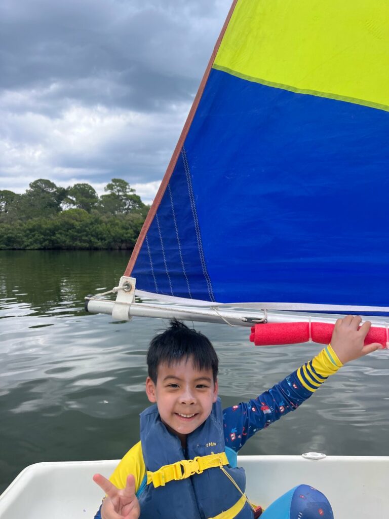 Boy sailing at watersports summer camp